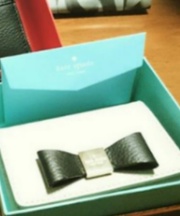 ベージュに黒いリボンがついたパスケース（ケイト・スペード）の画像