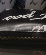 黒の長財布、白い英文、合皮の画像