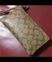 茶色いcoachの長財布と白いトートバッグの画像