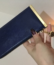 金色のハートのチャームがついた青いミニ財布の画像