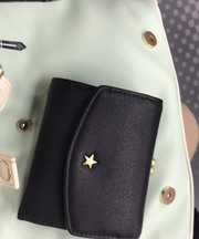 黒い折りたたみ式の財布でがま口と一緒になっています。の画像