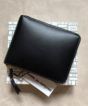 黒い革製の二つ折り財布、コムデギャルソンの画像