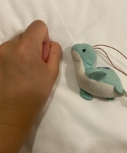 水色の拳より一回り小さい恐竜のマスコットの画像