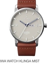 茶色の皮で円盤型で日付入力がさらている時計の画像